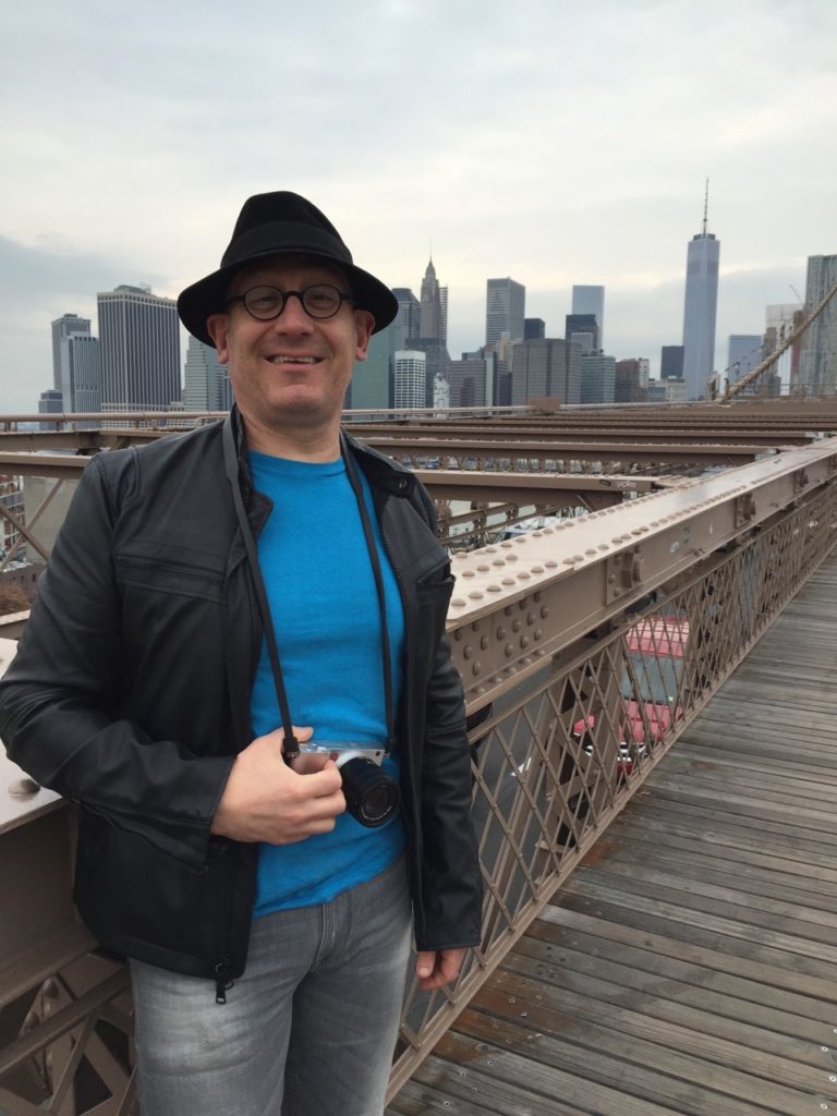Image of Michael in New York, skyline of Manhattan in background.