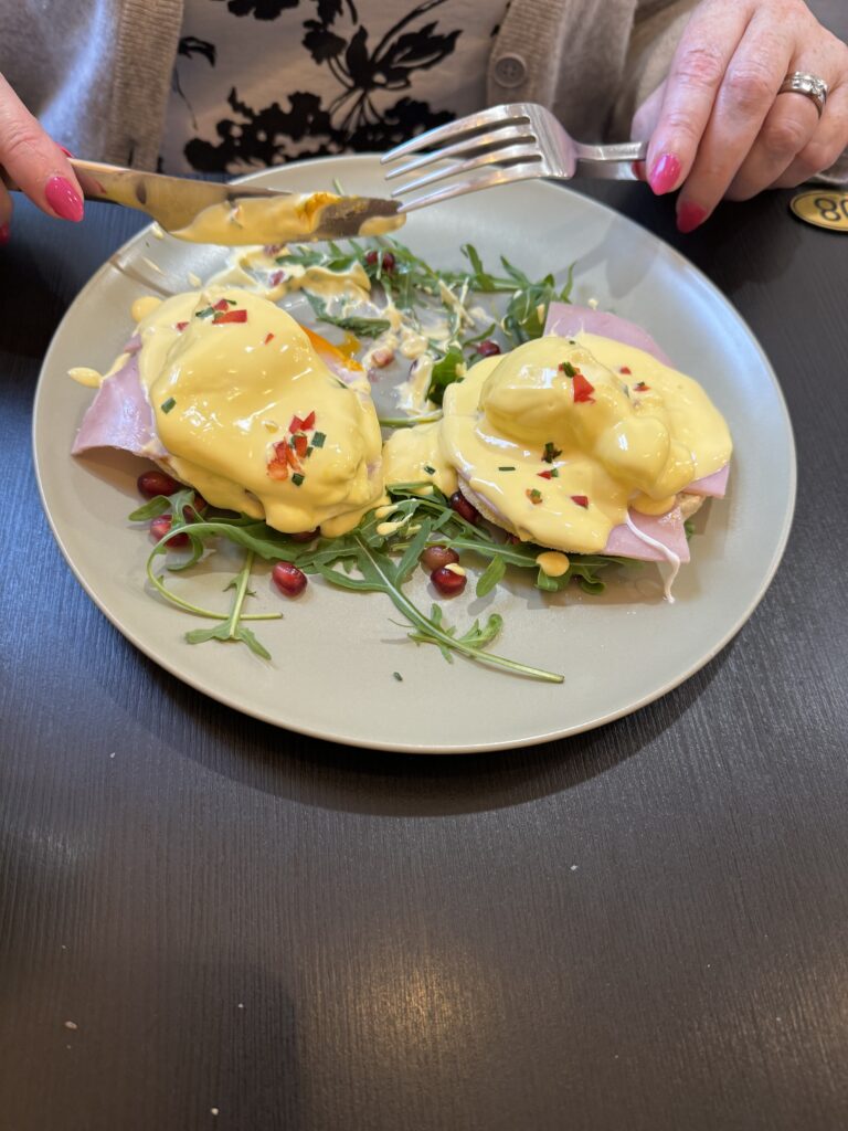 Mardi's eggs Benedict, eggs on a plate with hollandaise sauce and salad.
