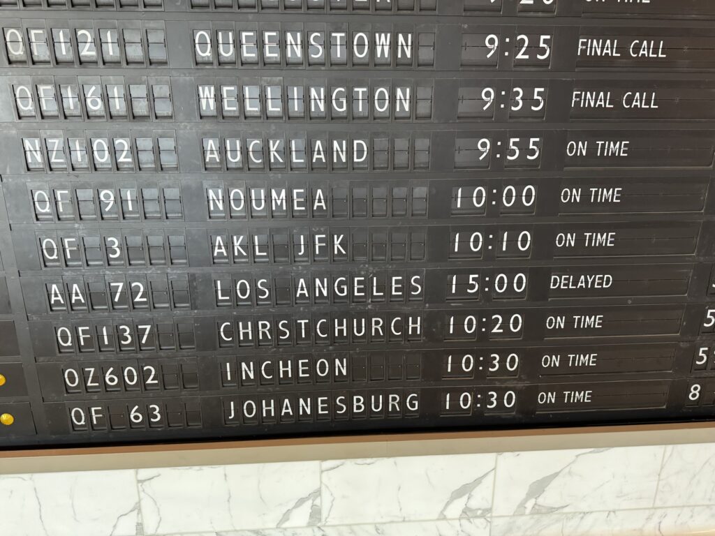 Old style departure board in the Qantas first lounge it shows outside to New York QF three departing at 10:10 am