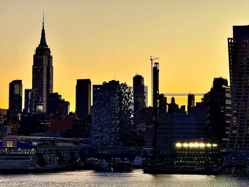 The NYC skyline in dilohette with a golden sky in the background.