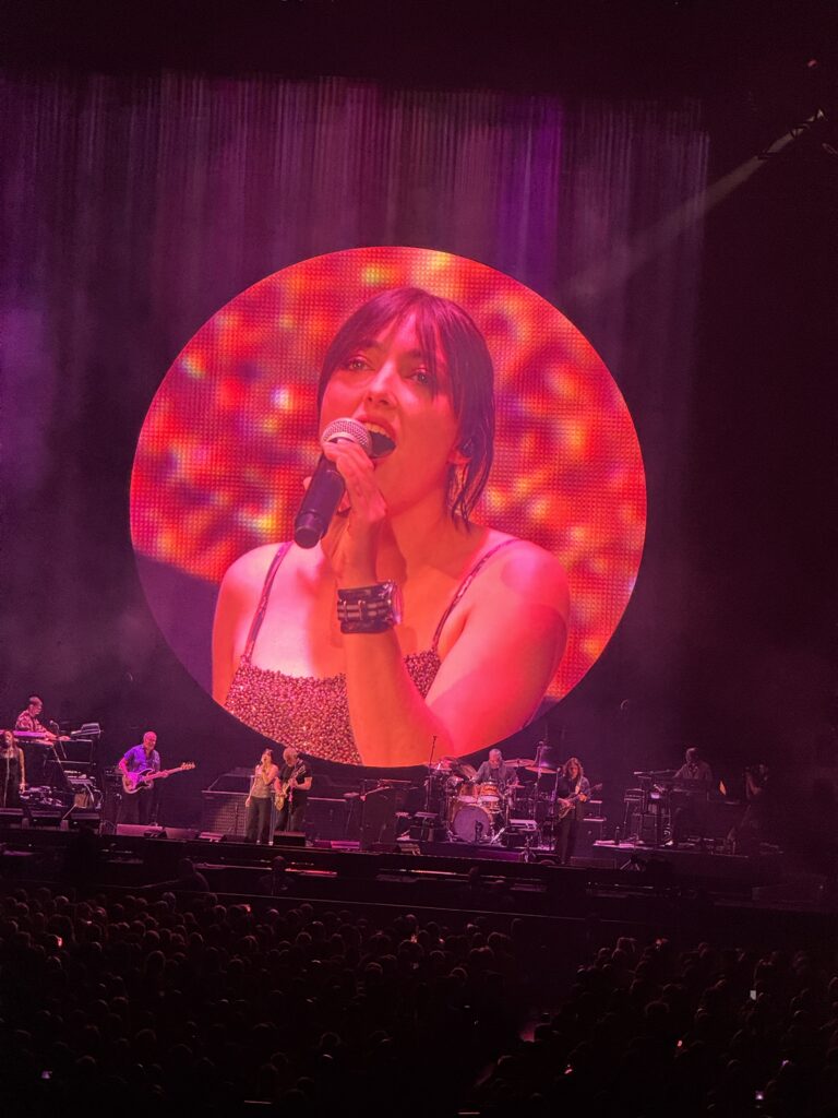 Romney Gilmour sings on the massive screen.